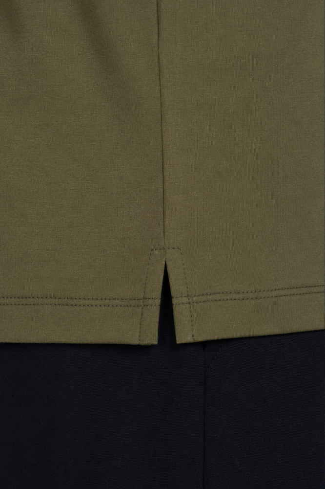Detalhe do acabamento da barra e fenda lateral da camiseta masculina verde em algodão duplo egípcio Urbô.