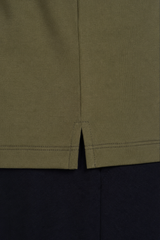 Detalhe do acabamento da barra e fenda lateral da camiseta masculina verde em algodão duplo egípcio Urbô.